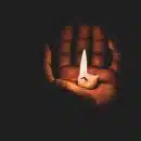 lit candle in hand