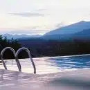 a swimming pool with mountains in the background