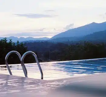 a swimming pool with mountains in the background