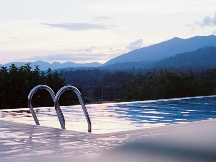 a swimming pool with mountains in the background